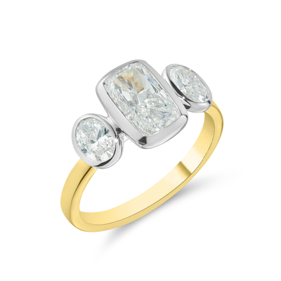 Two-tone gold ring with three diamond stones on a white background
