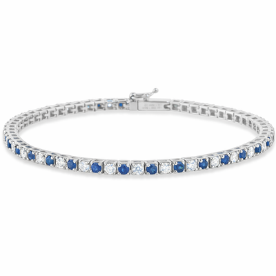 Silver bracelet with blue and clear gemstones on a white background
