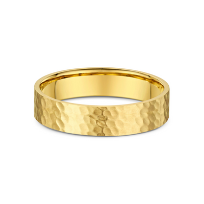 Gold ring with a textured surface on a white background
