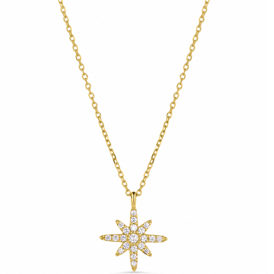 A gold chain necklace with a starburst pendant paved with small clear gemstones, shown against a plain white background.