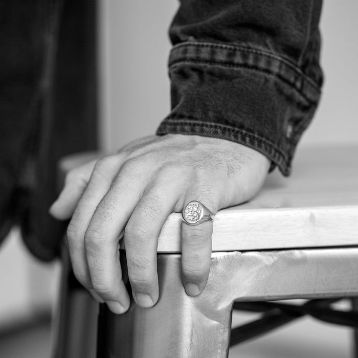 Person wearing a ring on a chair with a blurred background