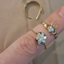 Gold rings with diamond-like stones on a beige fabric background