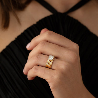 Model wearing engagement and wedding rings