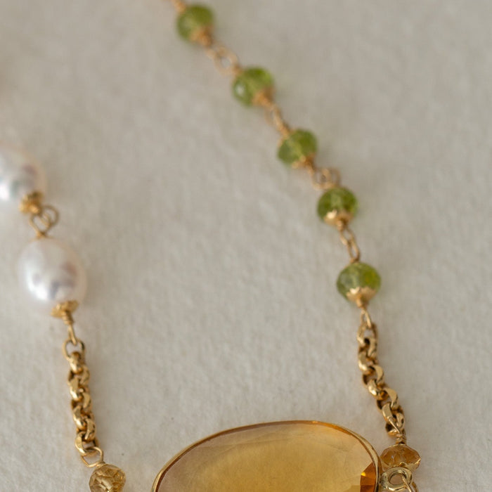 Necklace with a yellow gemstone pendant on a light background