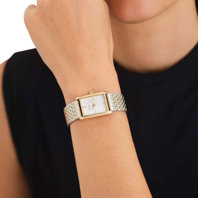 Gold watch on a wrist with a black background