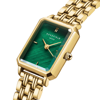 Gold watch with a green face on a white background