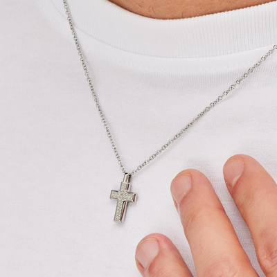 Silver cross necklace on a white background