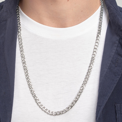 Silver chain necklace worn by a person with a white shirt and dark jacket.