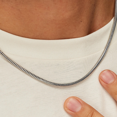 Silver chain necklace on a person wearing a white shirt