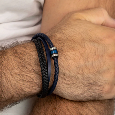 Close-up of a wrist wearing a braided leather bracelet with a metal clasp.