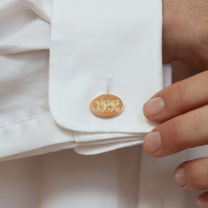 Gold cufflinks with initials on a white shirt